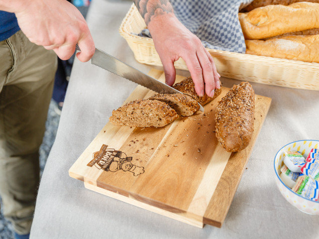 Stokbrood wordt aangesneden op een broodplank